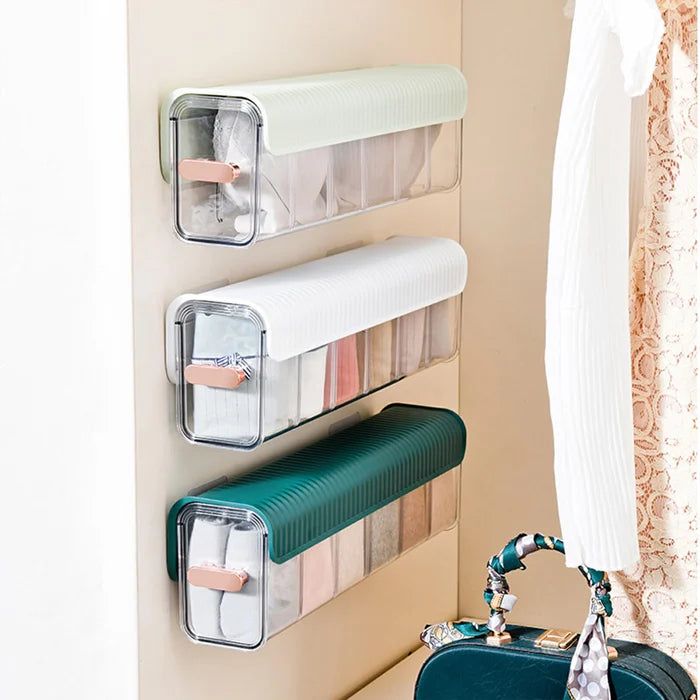 Wall-mounted underwear storage box with clear window, dust-proof cover, and self-adhesive installation. Adjustable compartments for versatile organization in closets, kitchens, or offices. No drilling required.