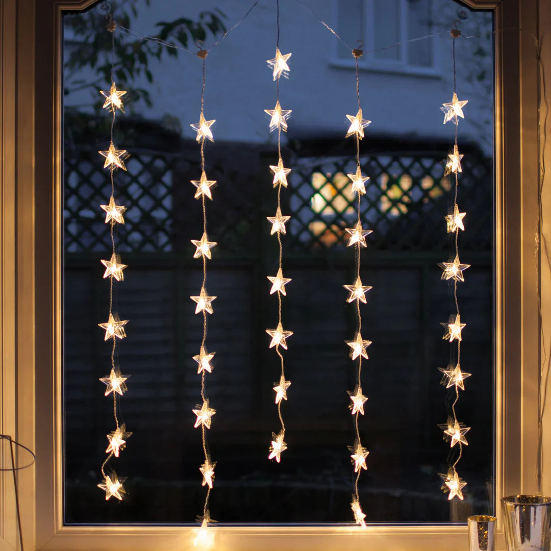LED star curtain lights, warm white star-shaped string lights, Lumora StarString lights for windows, enchanting indoor holiday decor lights.