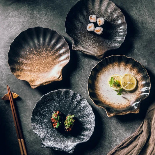 Rustic ceramic seashell plates with a speckled finish, ideal for sushi, appetizers, and small dishes, adding elegance to any table setting.