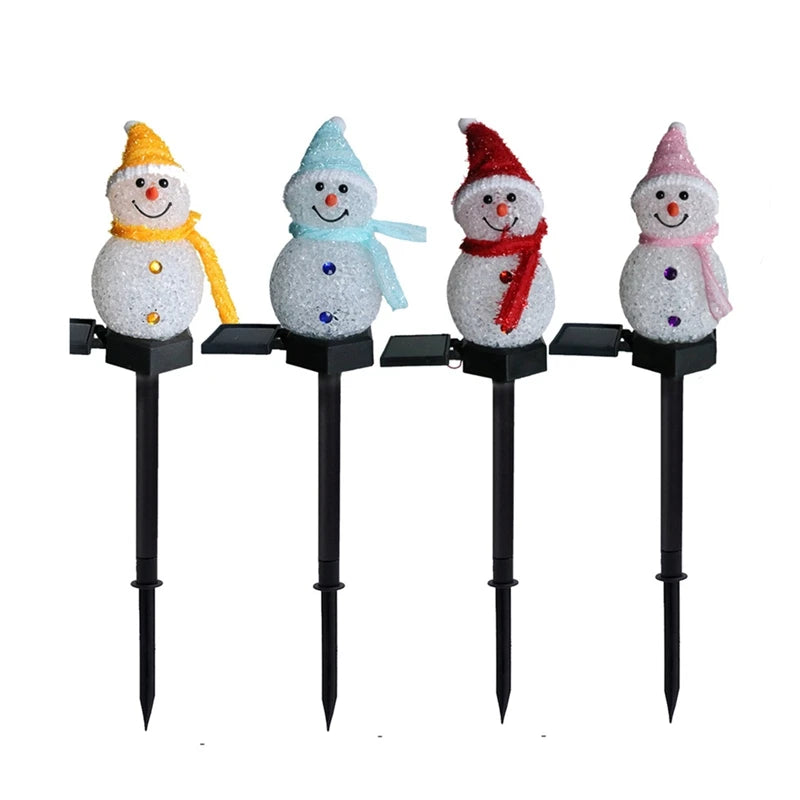LED snowman solar garden stake lights illuminating a festive outdoor lawn with Christmas decorations.