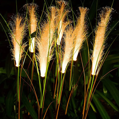 Solar reed garden lights illuminating a lawn with warm white LED glow, perfect for courtyards, parks, and outdoor decoration.