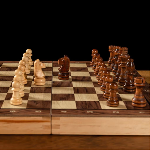 Wooden chessboard with pieces on a dark background