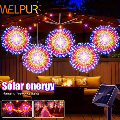 Hanging solar-powered firework lights with a vibrant display illuminating a backyard patio.